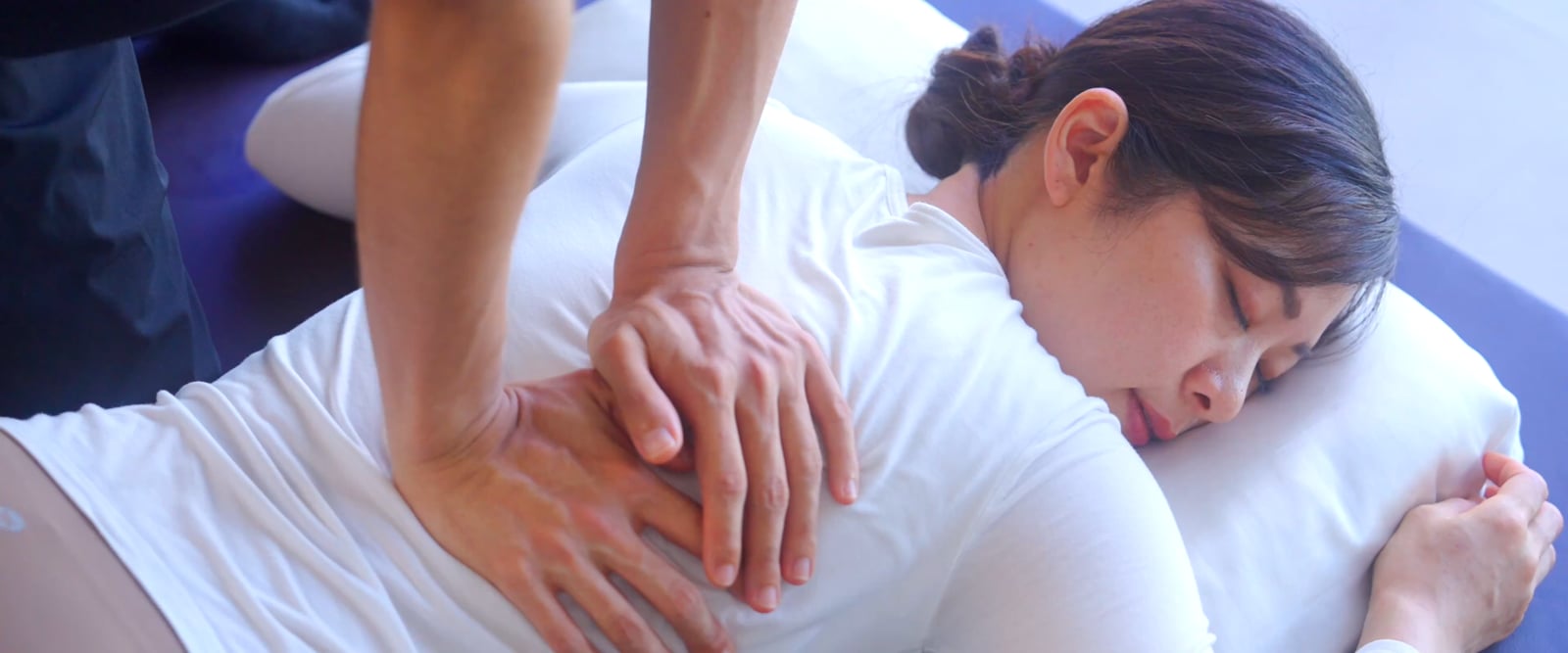 A woman relaxing during a massage, eyes closed