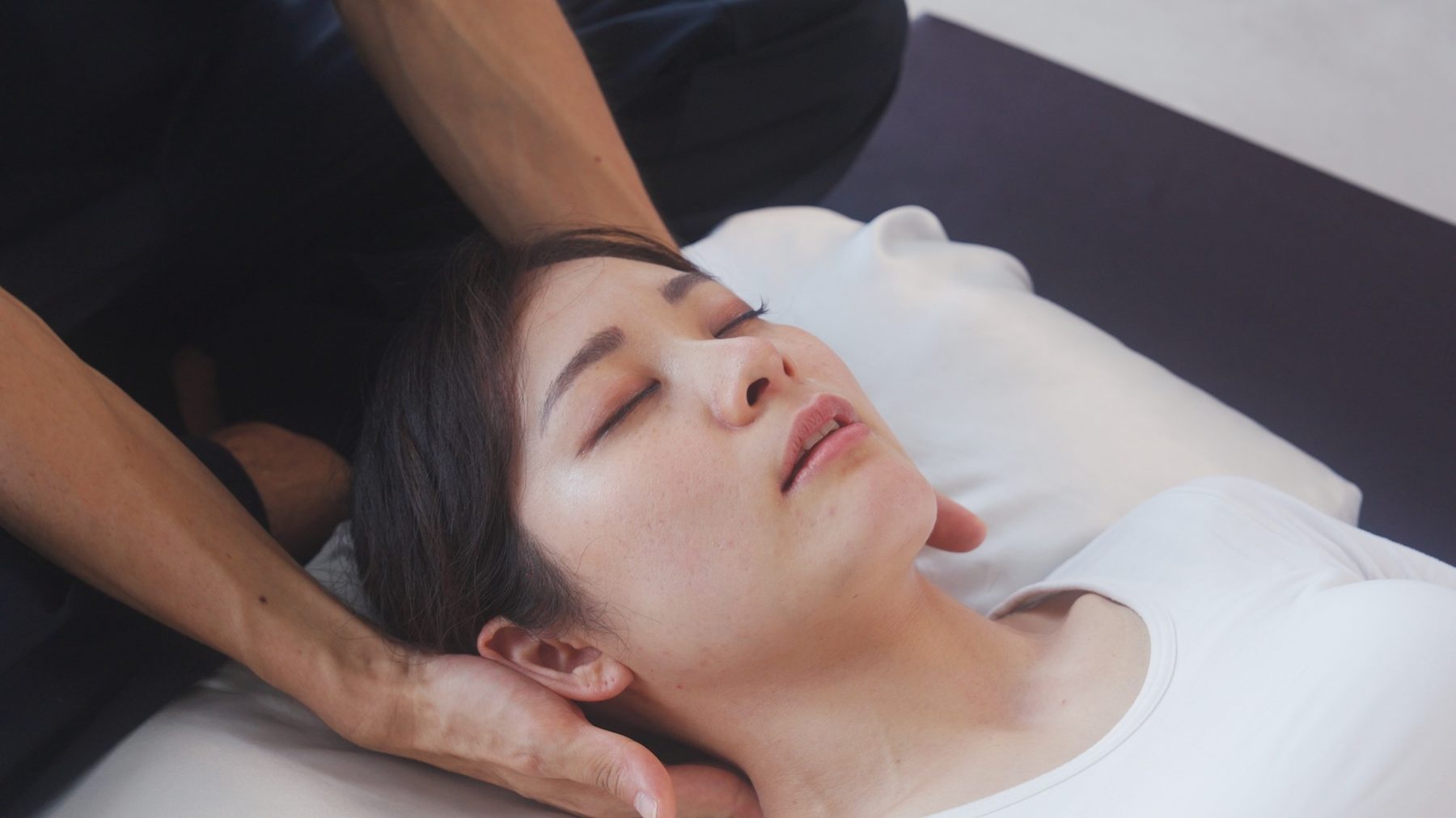 施術を受けて目を閉じる女性
